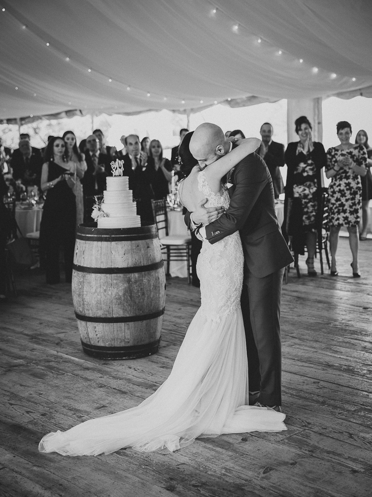 black and white photo of bride and groom hugging at their wedding reception