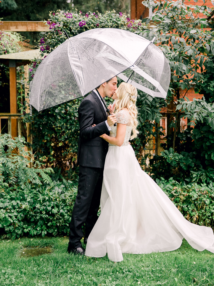 bride and groom kissing under umbrella after their first look in hamilton
