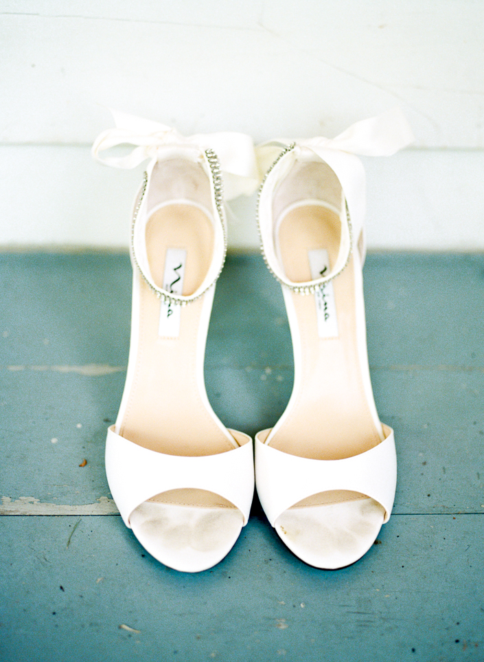 photo of white bridal shoes with a bow at the doctor's house bridal suite