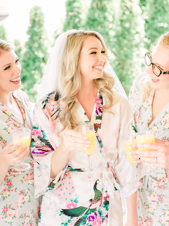 bride in her robe drinking mimosas with her bridesmaids