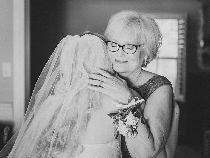 black and white photo of bride hugging her mom 